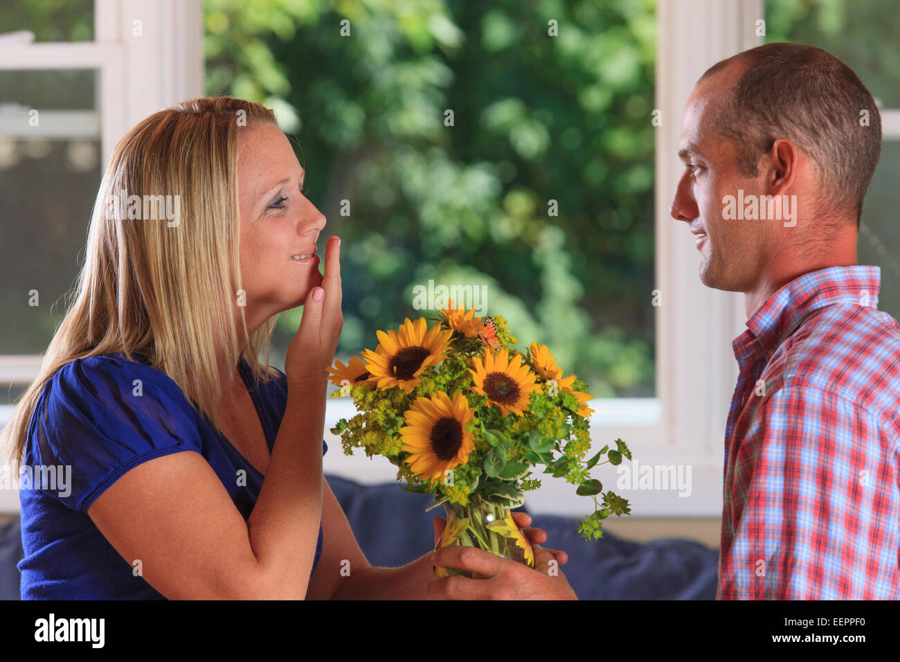 Mann, Blumen an seine Frau, die Unterzeichnung "Thank You" in amerikanischer Gebärdensprache beide mit Hörschädigungen Stockfoto