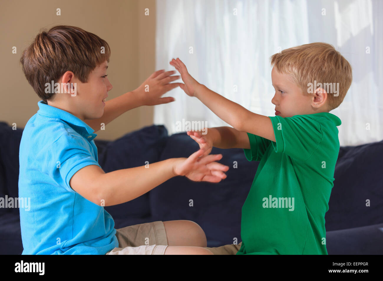 Jungen mit Hörschädigungen Unterzeichnung "sicher" in amerikanischer Gebärdensprache auf ihrer couch Stockfoto