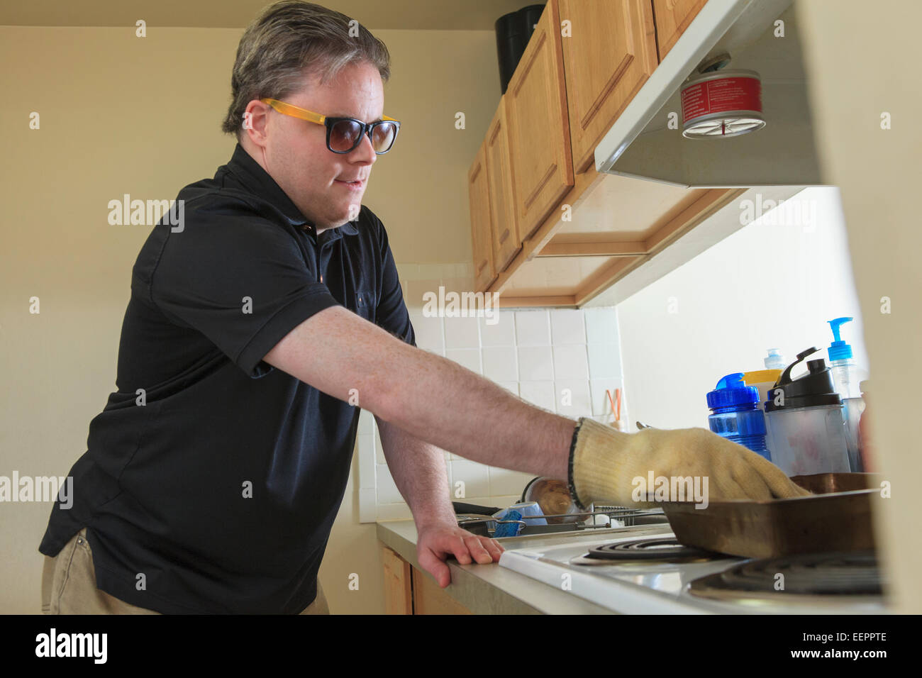 Menschen mit angeborenen Blindheit mit seiner Küche Herd Stockfoto