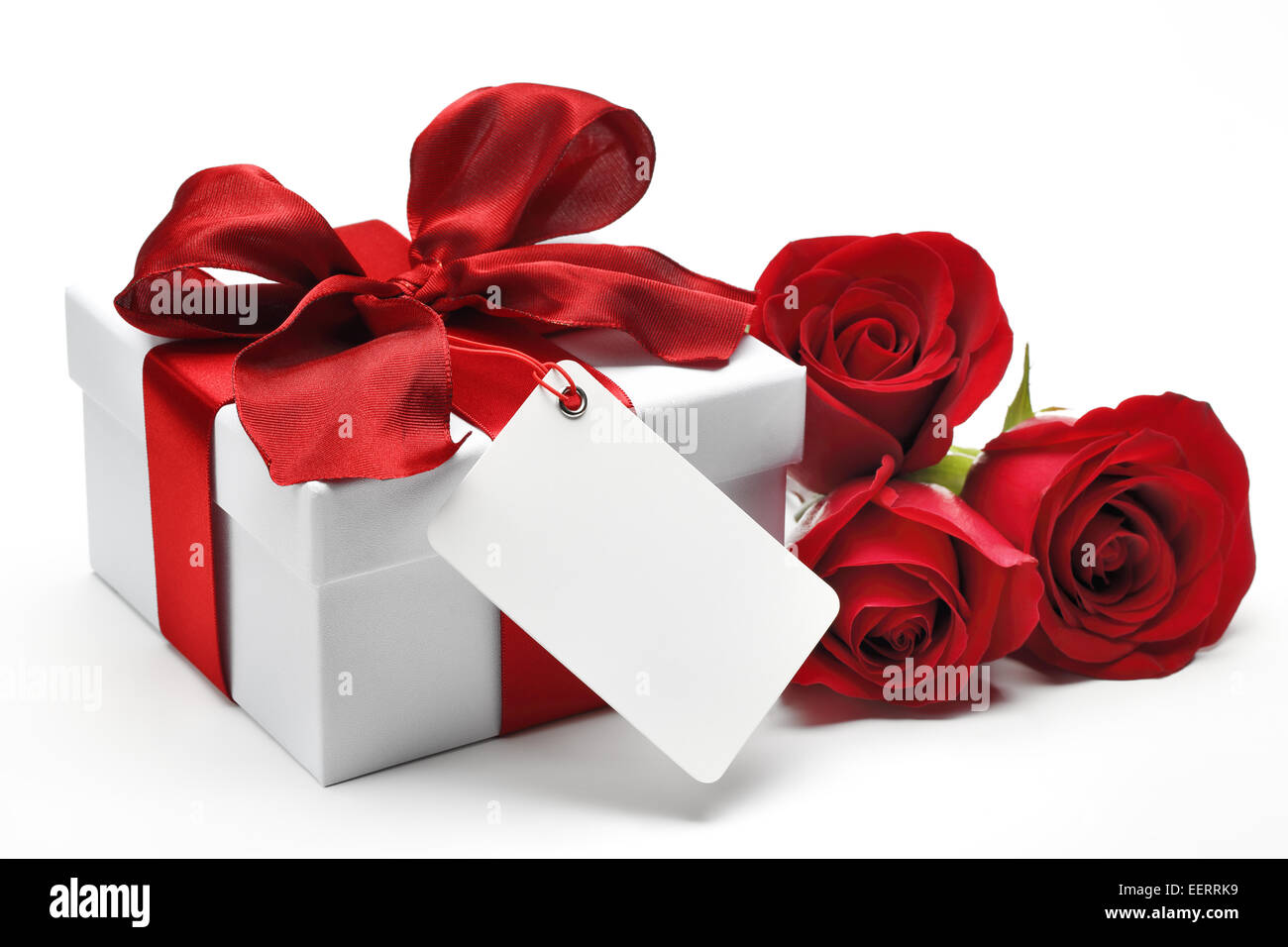 Bouquet von roten Rosen und Geschenk-Box mit einer leeren Karte auf weißem Hintergrund Stockfoto