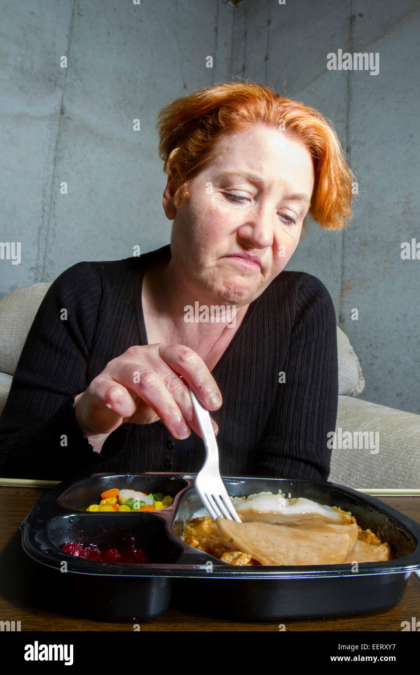 Unglückliche Frau, die ein TV-Dinner Essen Stockfoto