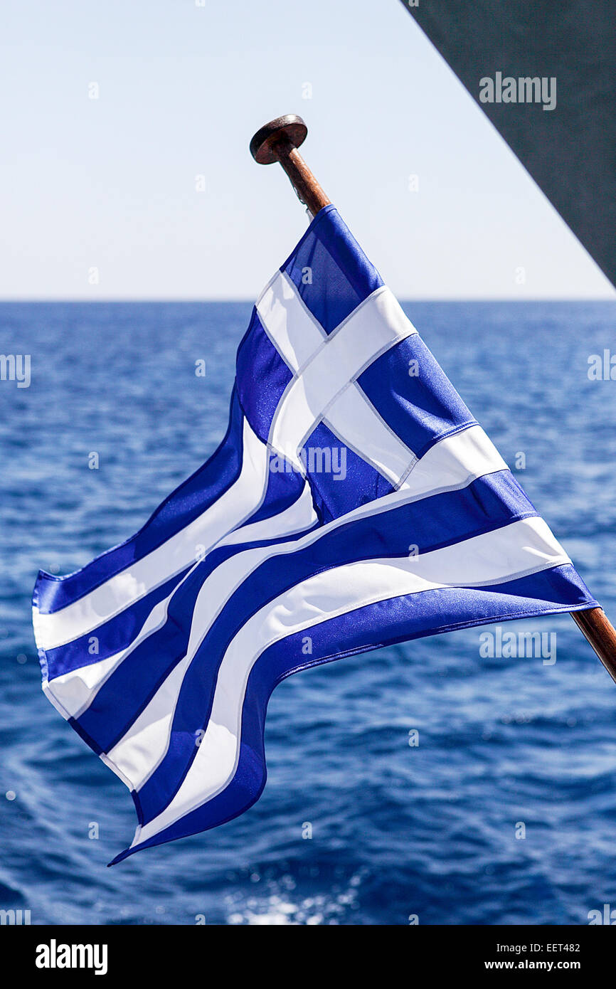 An Bord ein Meer gehen, Kreuzer, die griechische Nationalflagge, gesehen hier in starker Wind flattern angesehen. Stockfoto