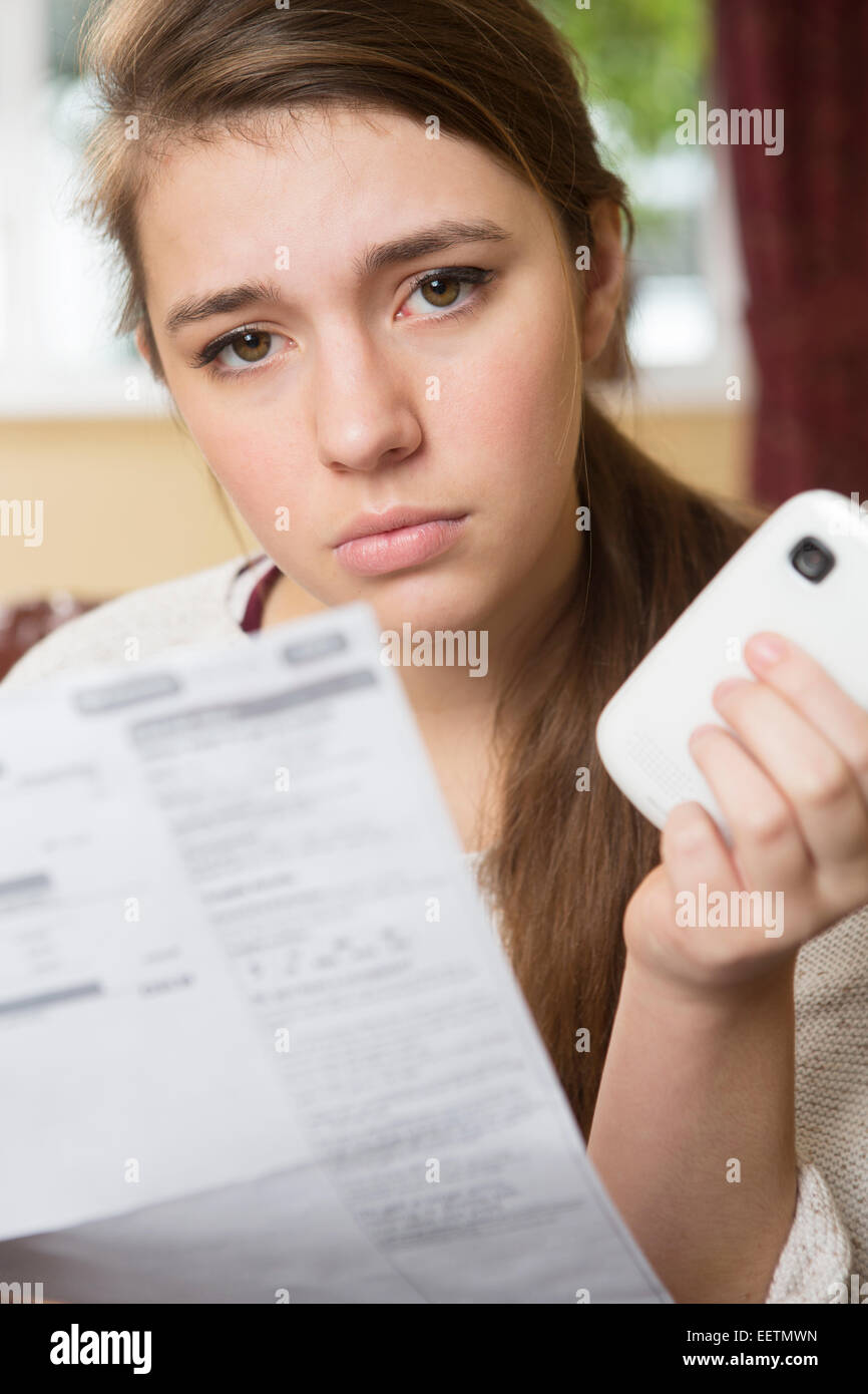 Teenage Girl Studying Handyrechnung suchen besorgt Stockfoto