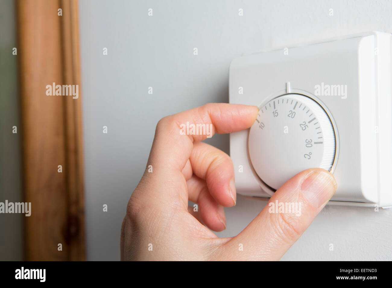 In der Nähe der weiblichen Hand auf zentrale Heizung Thermostat Stockfoto