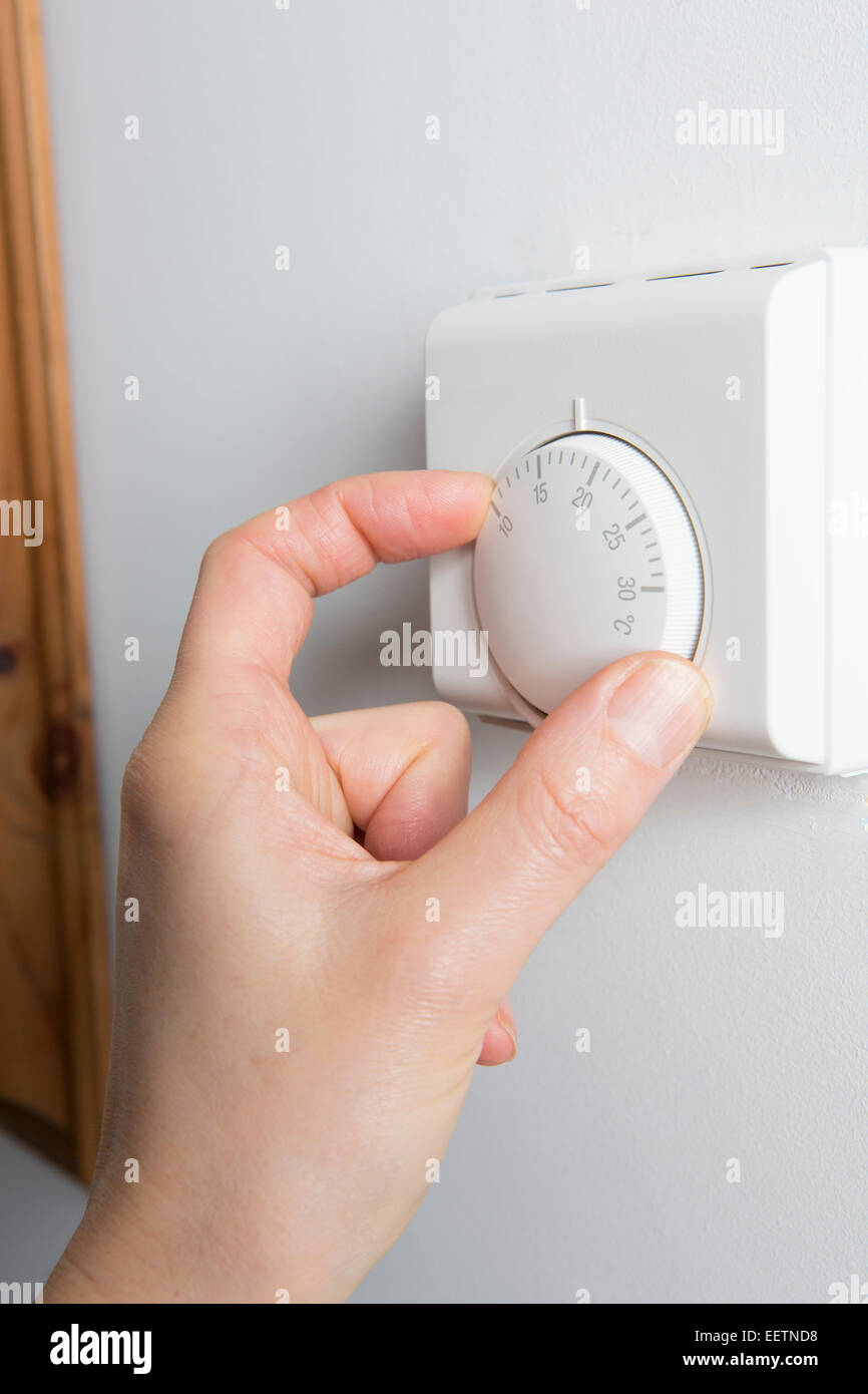 In der Nähe der weiblichen Hand auf zentrale Heizung Thermostat Stockfoto