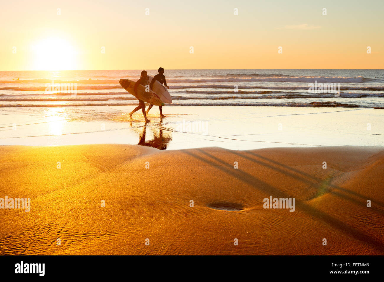 Zwei Surfer am Strand bei Sonnenuntergang laufen. Portugal ist eines der besten Surf-Szenen in Europ Stockfoto