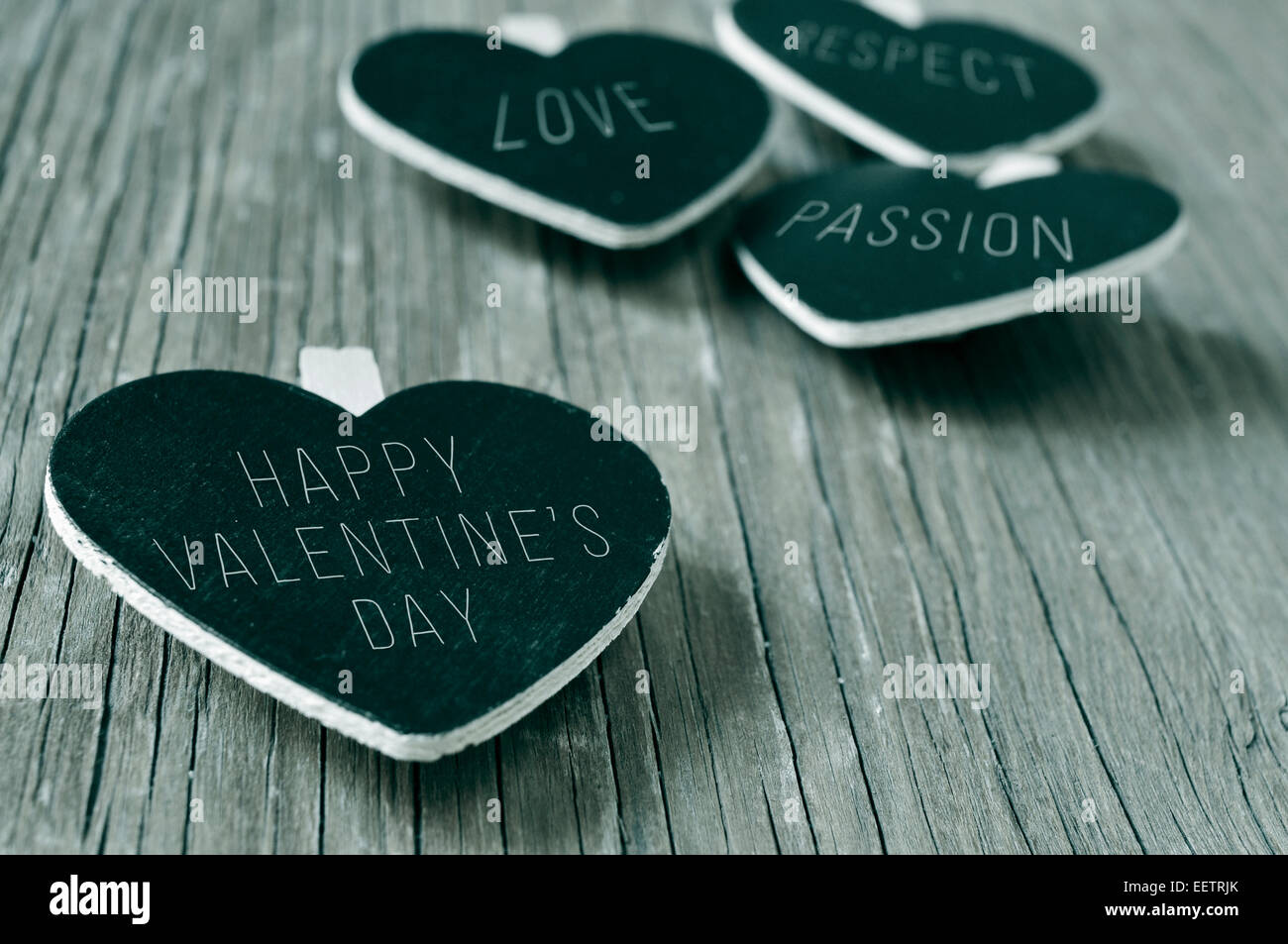 Worte Liebe, Respekt und Leidenschaft, und der Satz glücklich Valentinstag in einige herzförmige Tafeln auf einem rustikalen Woo geschrieben Stockfoto