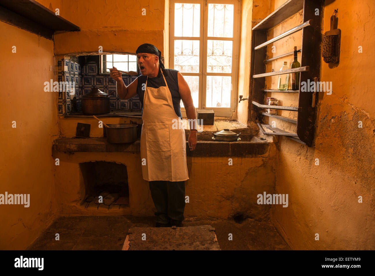 Männliche kochen Suppe in einer altmodischen Küche Verkostung Stockfoto