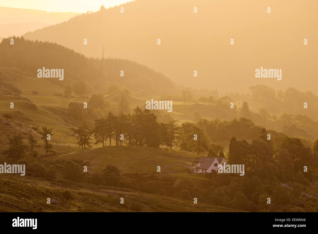 Ein Haus steht allein in Snowdonias dramatischen, zerklüftete Landschaft.  Warmes Licht flutet das Tal der Sinn für Dramatik hinzufügen. Stockfoto