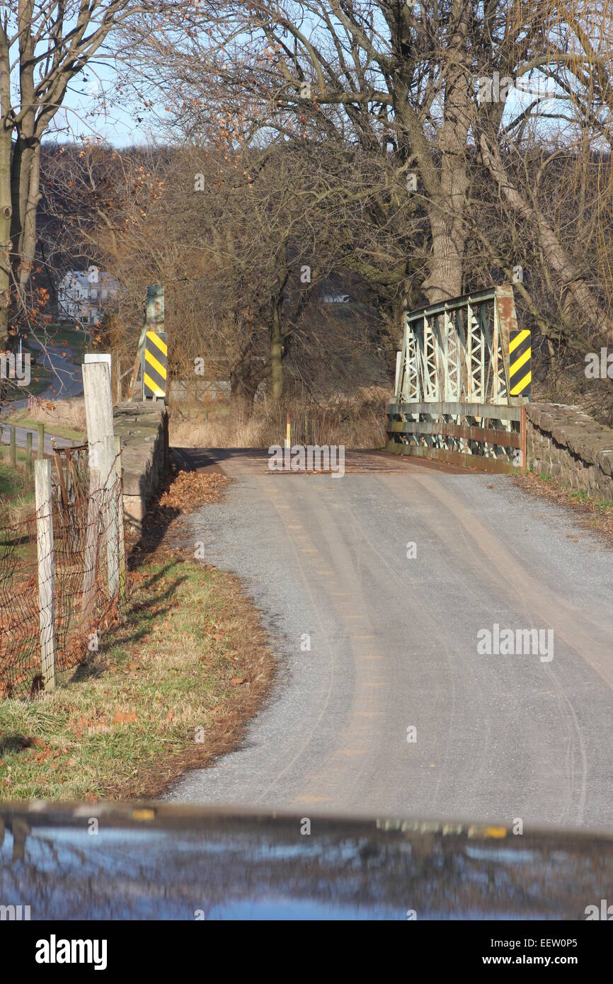 Rustikale alte, schmale Brücke auf eine alte, gut gebrauchte Landstraße Stockfoto