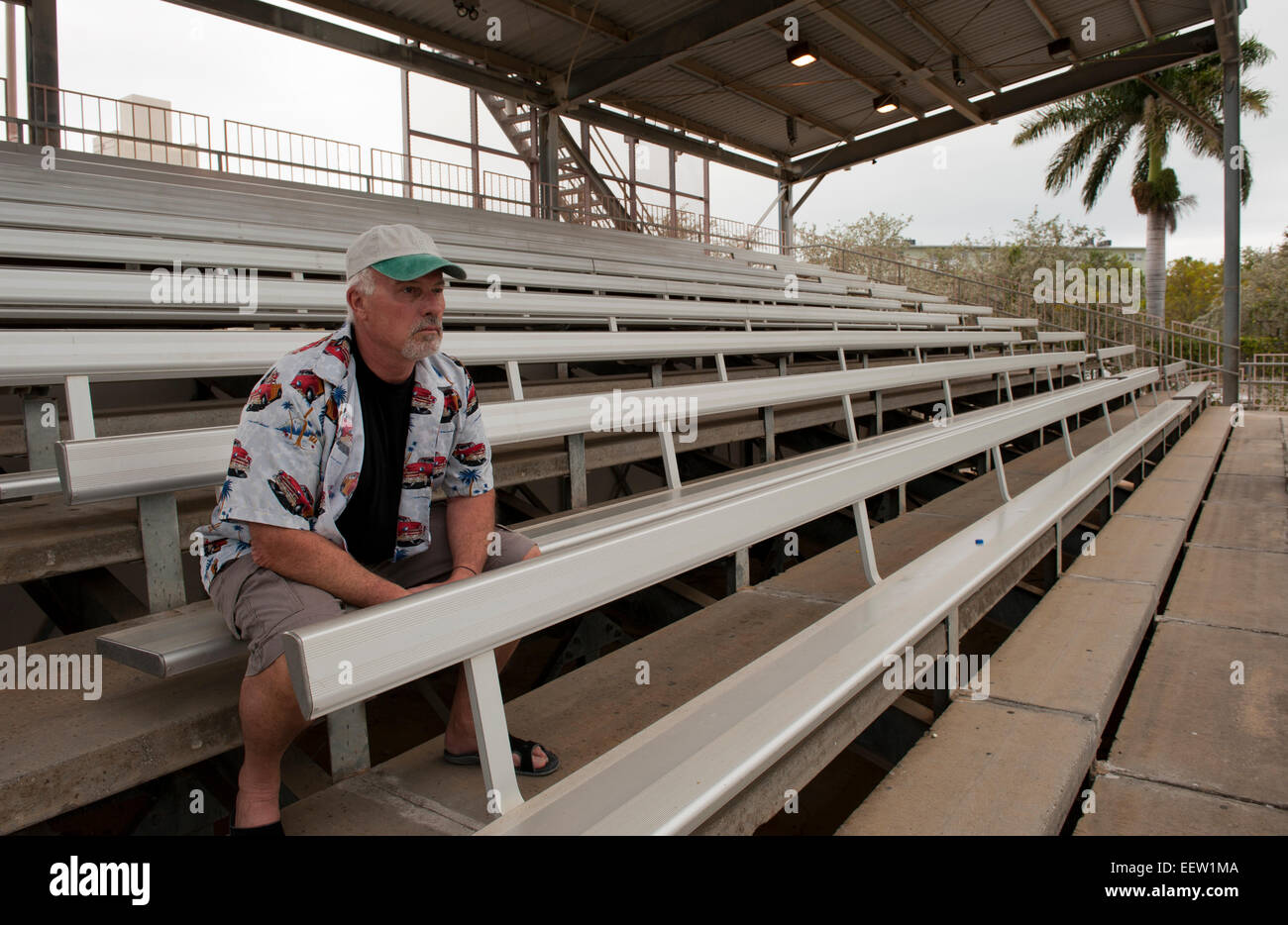 Reifer bärtiger Mann in eine Baseball-Cap, die gerade ein Spiel aus leeren Rängen Stockfoto