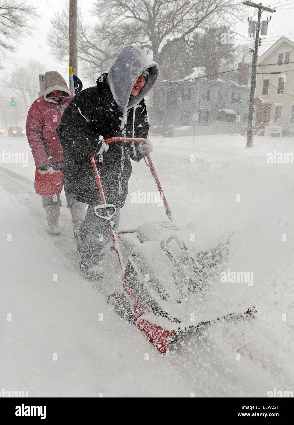 New Haven--14-j hrige Kyle Petrone weht Schnee auf dem Gehweg entlang der Whitney Avenue, gefolgt von seiner Mutter, Christina Wilkus, als sie versuchten, die morgen Schneefälle voraus.   21.01.12 Stockfoto