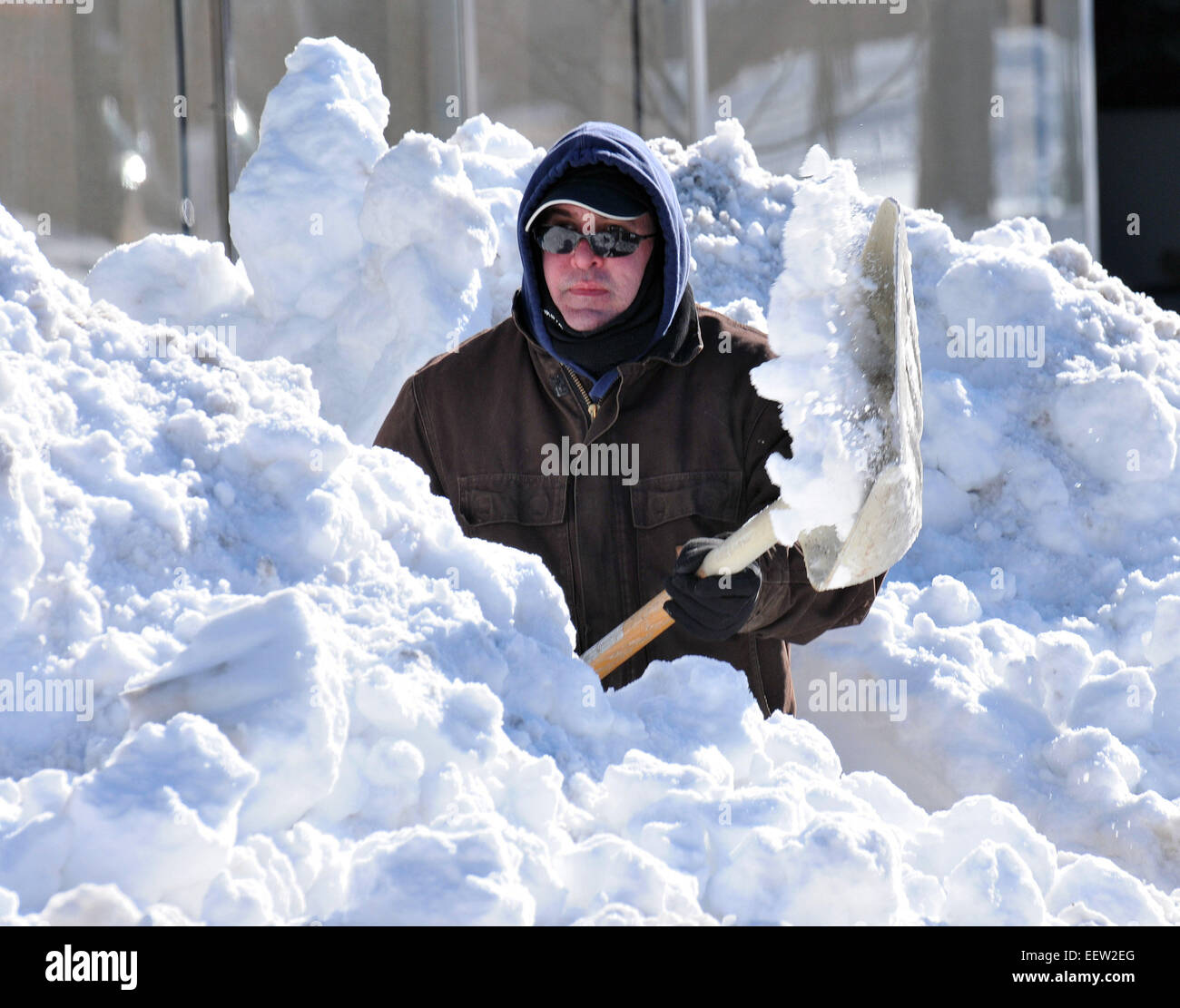 New Haven--löscht ein Mann Schnee entlang Whalley Avenue und Brunnen Street. Stockfoto