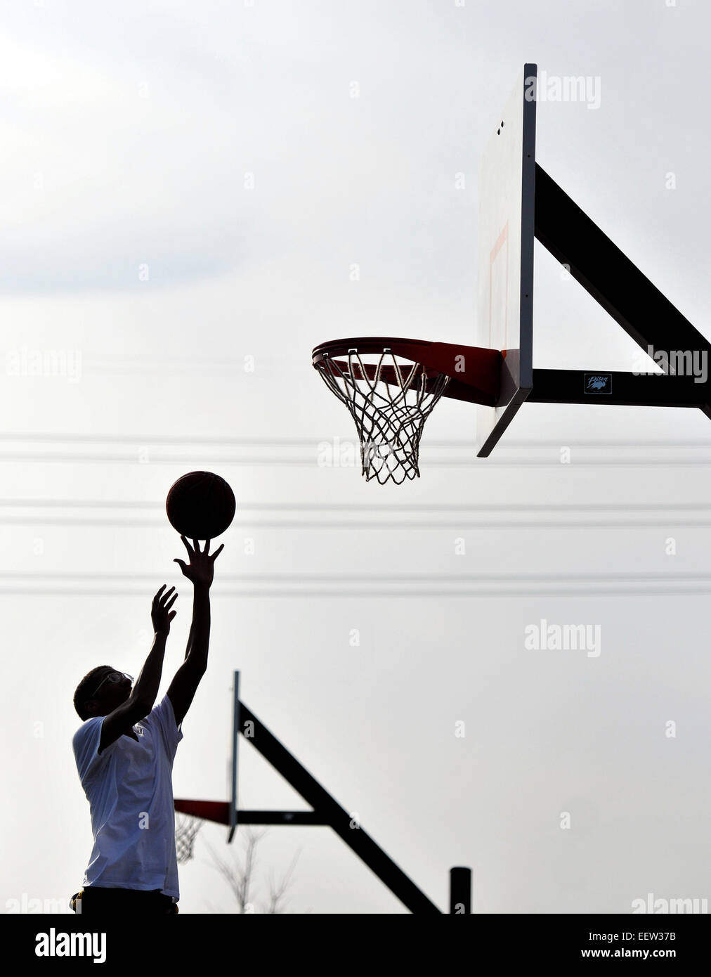 Jayqwan Wilkins von New Haven genießt das frühlingshafte Wetter, da er Basketball mit Freunden im Criscoulo Park in New Haven spielte. Stockfoto