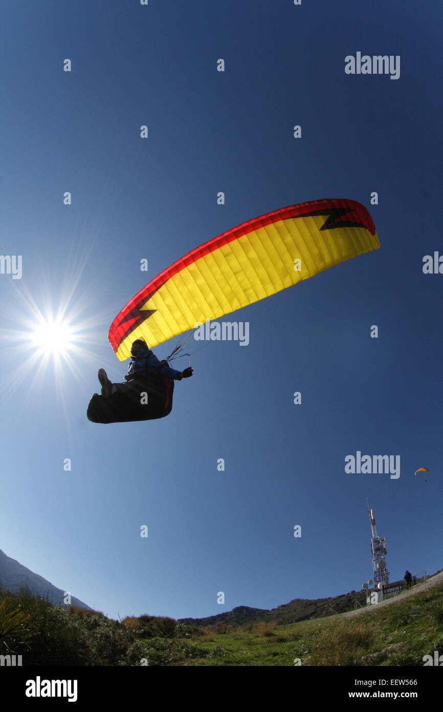 Gleitschirmpiloten soaring gegen blauen Himmel Stockfoto