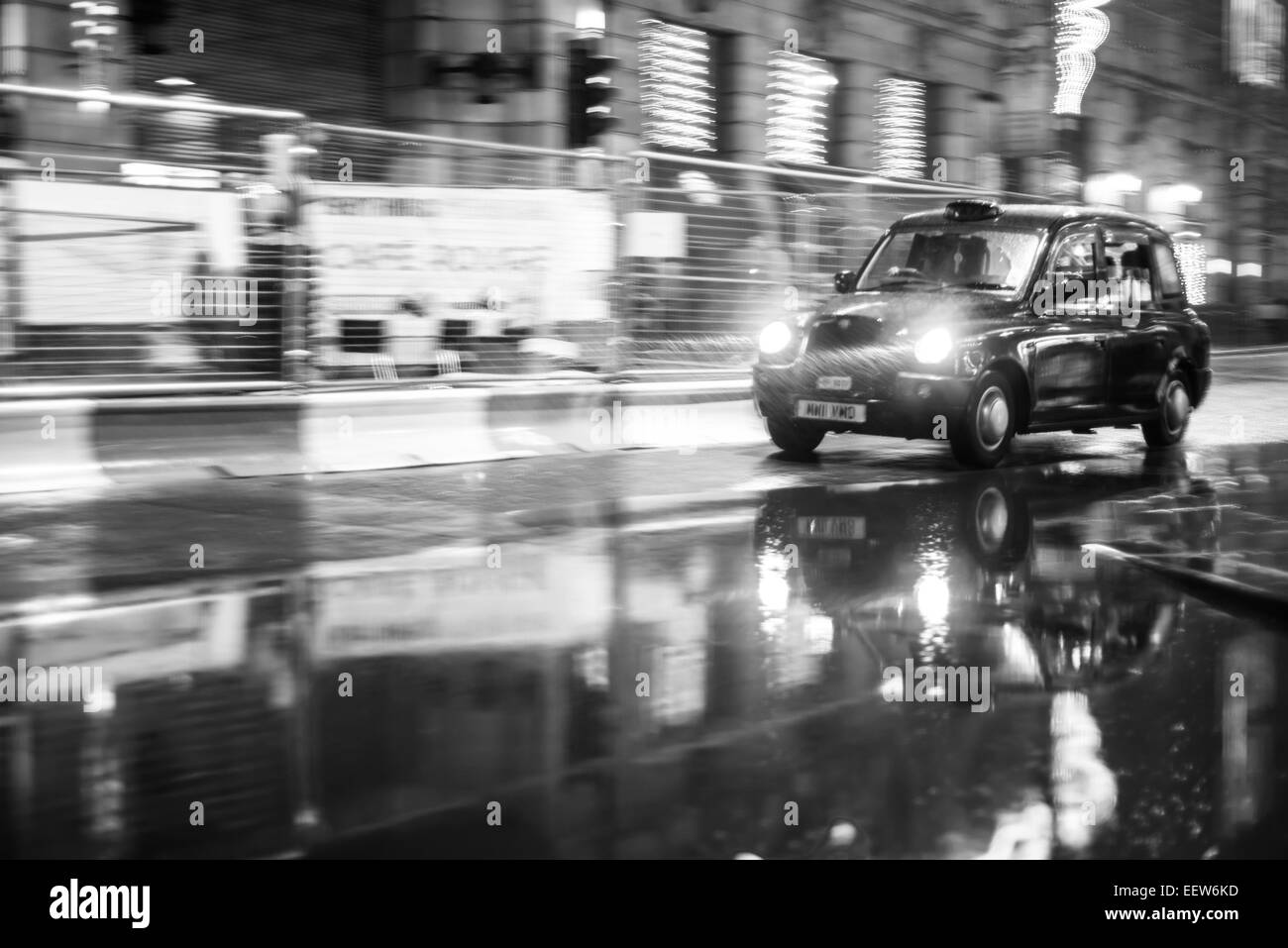 Eine englische Taxi macht seinen Weg durch den Regen. Stockfoto