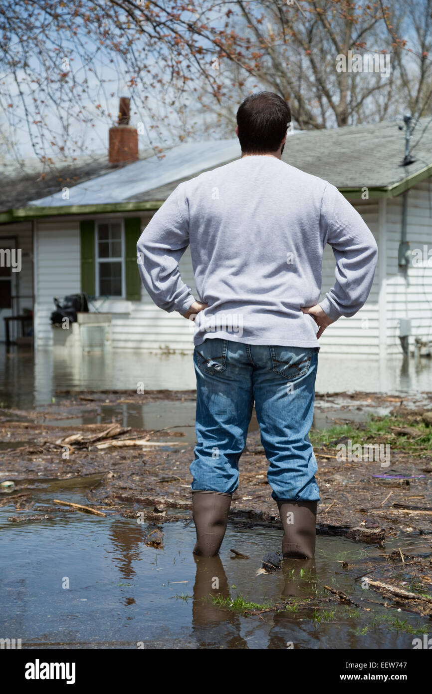 Mann stand vor überfluteten Haus Stockfoto