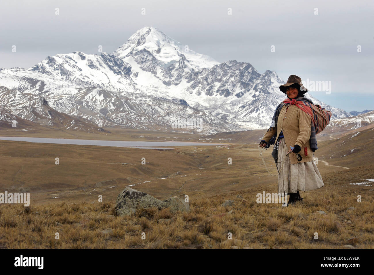 Hoch in den Anden führt eine Schäferin vor dem Hintergrund der Huayna Potosi Gipfel Boliviens. Stockfoto