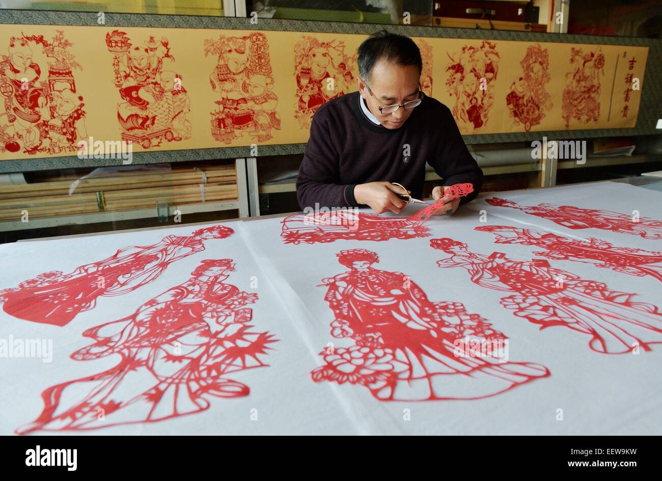 Hejian, Chinas Provinz Hebei. 21. Januar 2015. Volkskünstler Song Baoshu macht Papierschnitten in Hejian Stadt, Nordchinas Provinz Hebei, 21. Januar 2015. Mit einem paar der Schere und etwas Papier können chinesische Handwerker Papierschnitten mit komplizierten Mustern und Bildern erstellen. Als Papierschnitt im Blut läuft, widmet der 61 Jahre alte Lied Baoshu sich bewahren. © Zhu Xudong/Xinhua/Alamy Live-Nachrichten Stockfoto