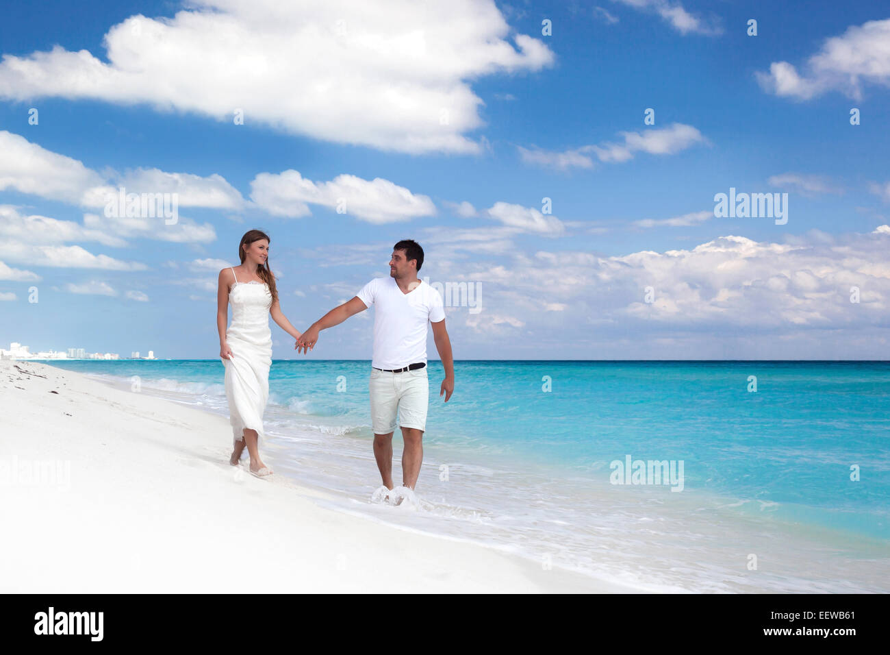 Junge schöne Brautpaar in Liebe Hand in Hand und Fuß am tropischen Sandstrand Stockfoto