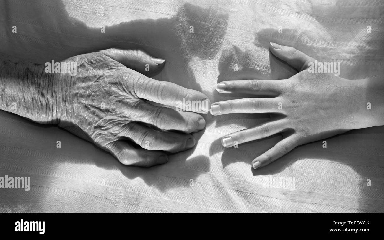 Händen der Großmutter und Enkel im Bett Stockfoto