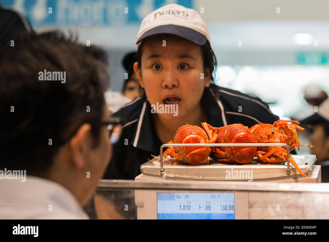 Frau Fischhändler mit einem Gewicht von Muscheln auf Peters Fischmarkt, ein Geschäft im Sydney Fish Market, am Heiligabend 2014. Australien Stockfoto