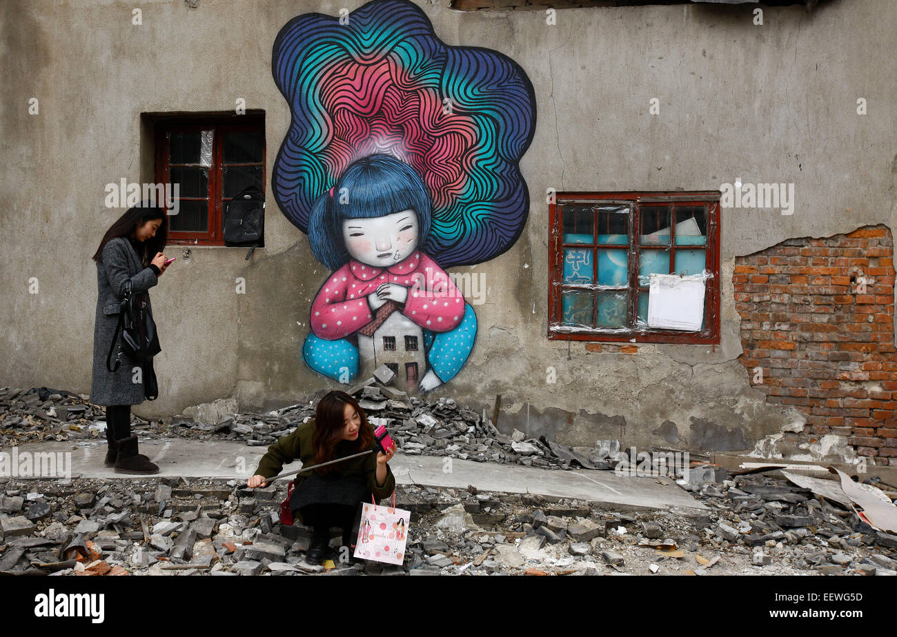 (150122)--SHANGHAI, 22. Januar 2015 (Xinhua)--Bürger machen Sie Fotos von Graffiti Paingtings Wandmontage in Shanghai, Ost-China, 22. Januar 2015 abgerissen. Graffiti-Gemälde fanden sich kürzlich auf Schutt in einer Wohn Lane, wo alte Häuser abgerissen wurden.  (Xinhua/Fang Zhe) (Angeles) Stockfoto