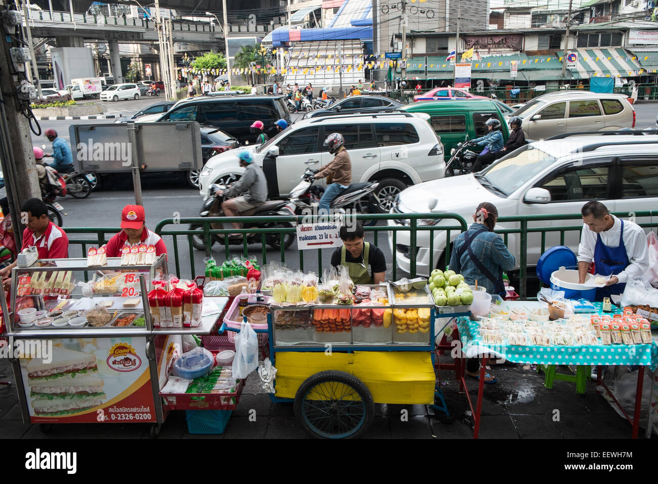 Roller warten an der Ampel an der Kreuzung der Asok und Sukhumvit. Verkehr, Verkäufer, Verkauf, Obst, Bangkok, Thailand, Asien. Stockfoto