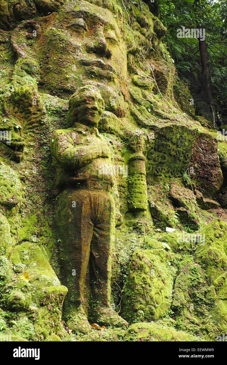 Moos bedeckt Stein Skulpturen im Garten des Ayung Resort, Ubud, Bali. Stockfoto
