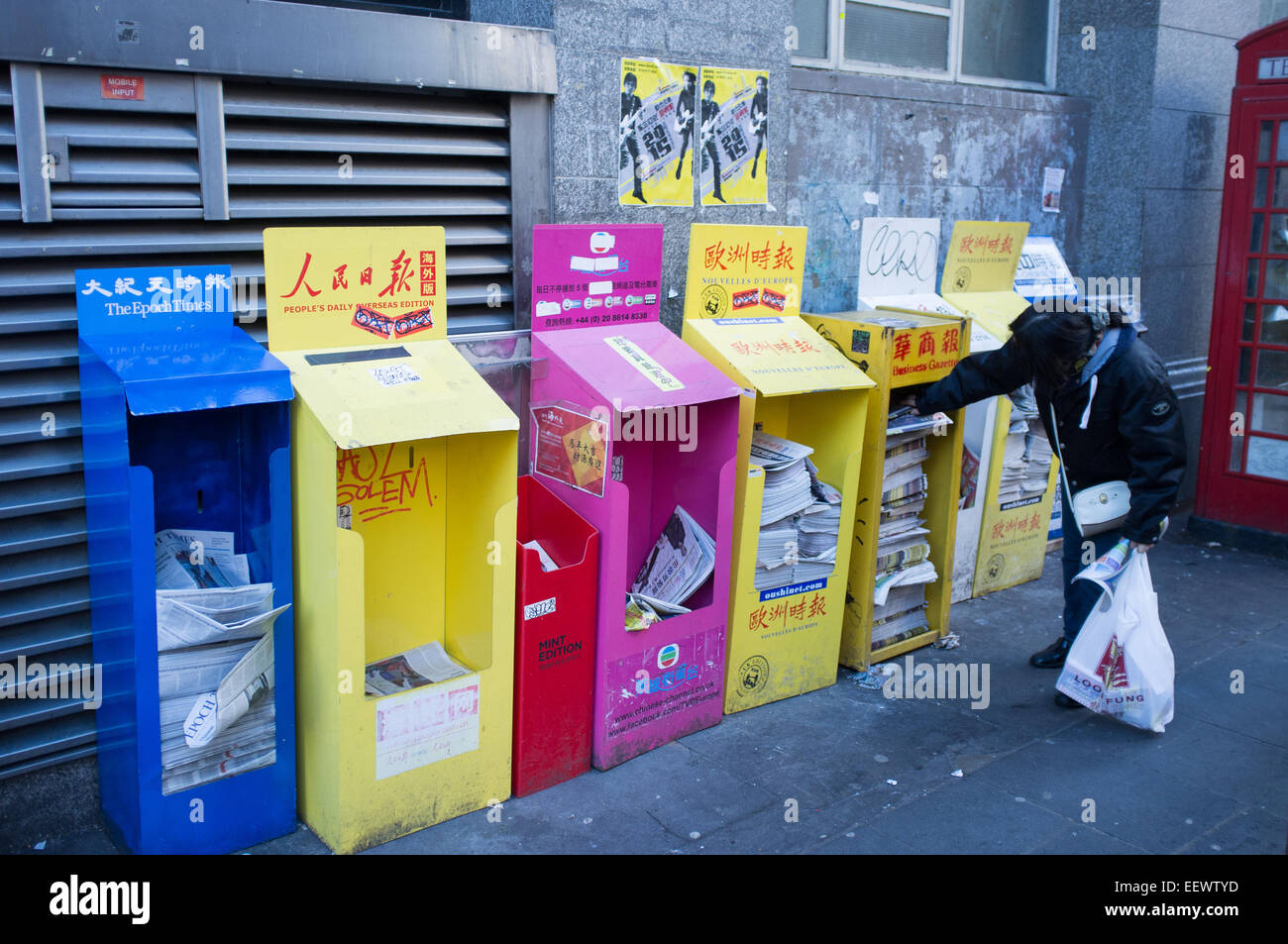 Eine Dame auf der Suche durch die Auswahl der chinesischen Zeitungen in Chinatown, Soho, London Stockfoto