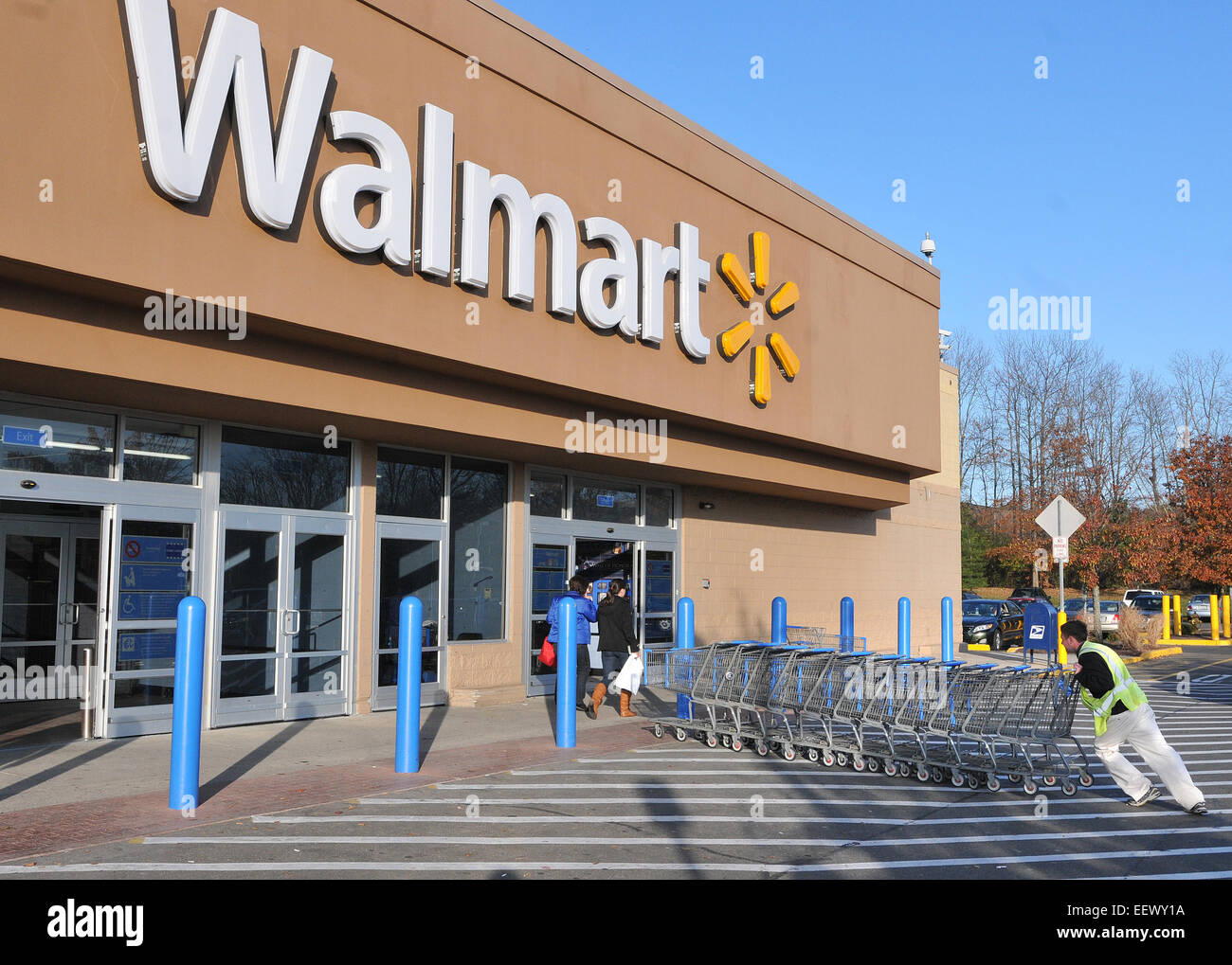 Branford CT USA - ein Arbeiter sammelt Karren bei Branford Walmart. Walmart öffnet morgen zum Weihnachtsgeschäft in die Läden. Stockfoto