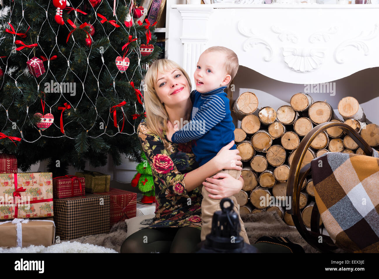Sohn umarmt seine Mutter in der Nähe von Christmas tree Stockfoto