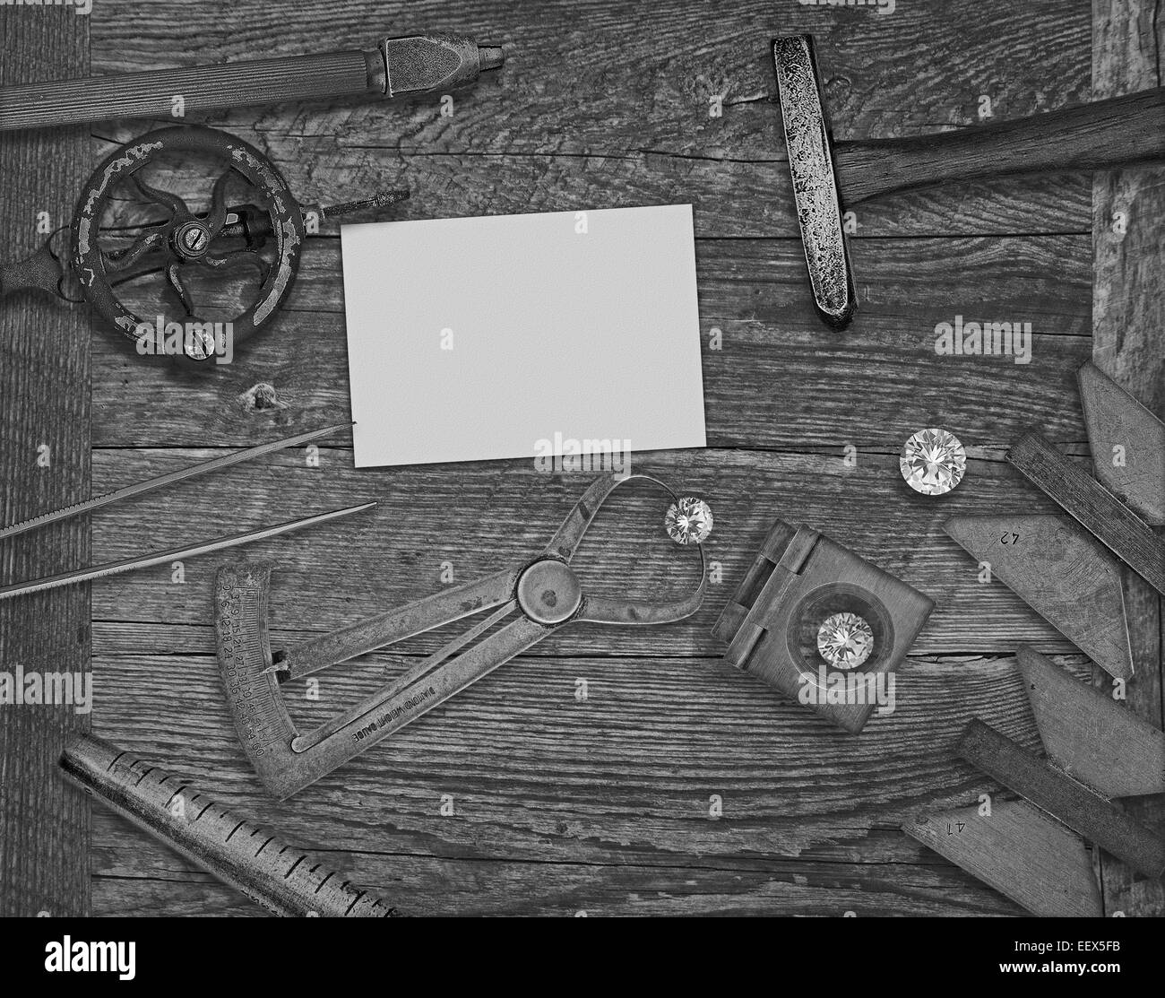 schwarz / weiß Bild einer Vintage Juwelier-Tools und Diamanten über Holzbank, Platz für Text auf eine leere Visitenkarte Stockfoto