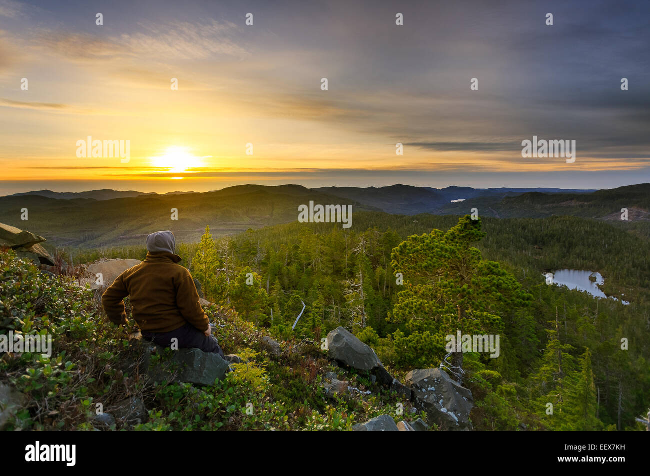 Wanderer genießen den Sonnenuntergang sitzen am Berghang Stockfoto