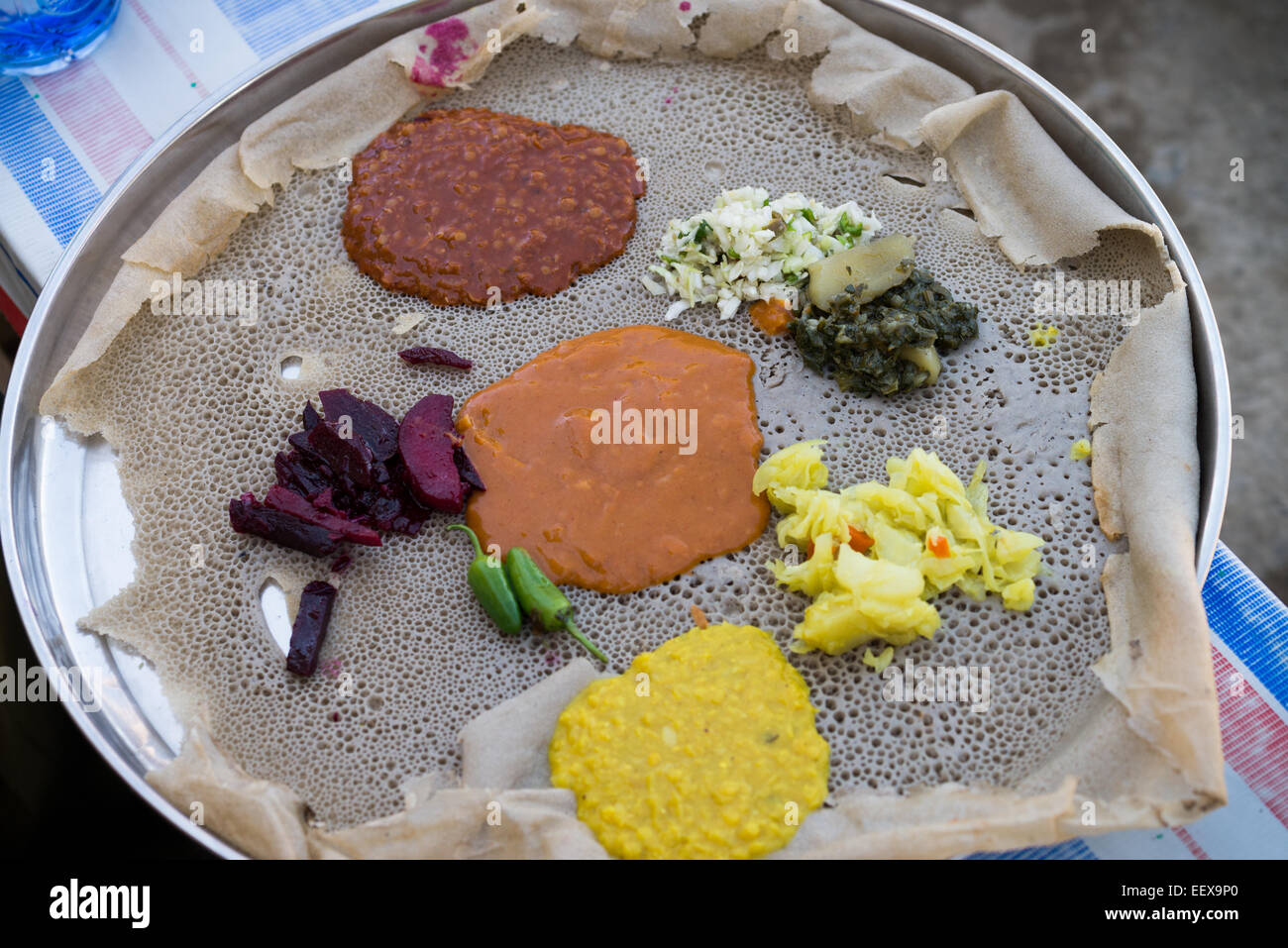 Traditionelle Äthiopische Küche, mehrere Arten von Saucen und Fleisch auf Injera serviert Stockfoto