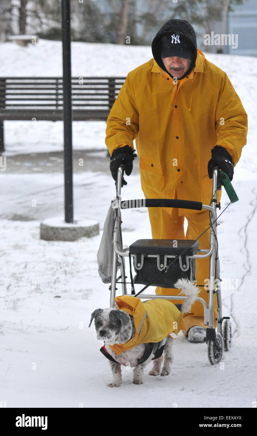 Frank Torino geht seinen Hund "Smokey" außerhalb der Bella Vista Apartments in New Haven, während am Samstag Schneesturm. Stockfoto