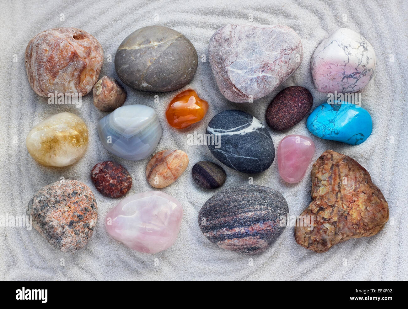 Kostbare Meer Steinen liegen auf weißem Quarz-Sand Makro-Hintergrund Stockfoto