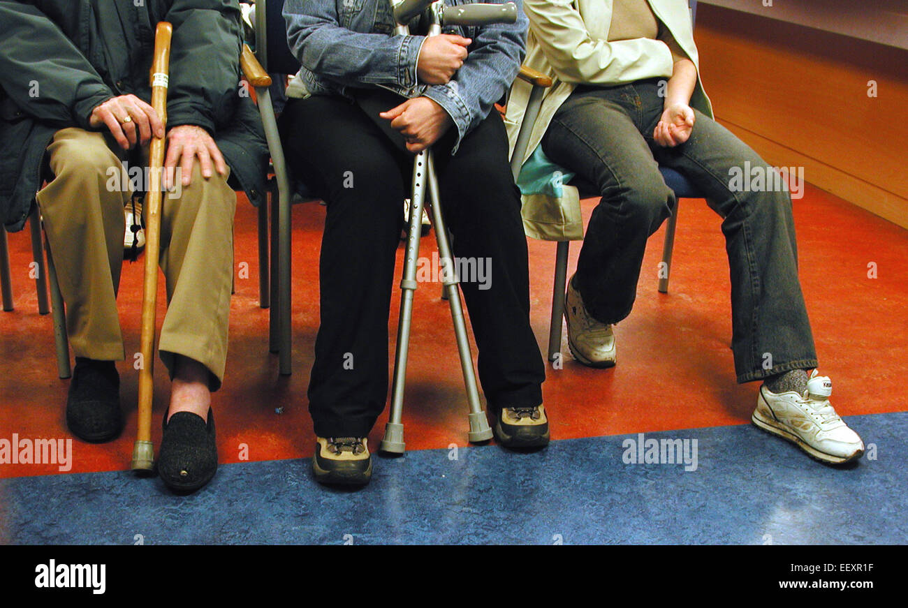 Patienten mit Krücken und Gehstöcken warten in der Wartehalle des NHS-Krankenhauses, London, Großbritannien – was die Nachfrage nach öffentlichen Gesundheitsdiensten hervorhebt Stockfoto