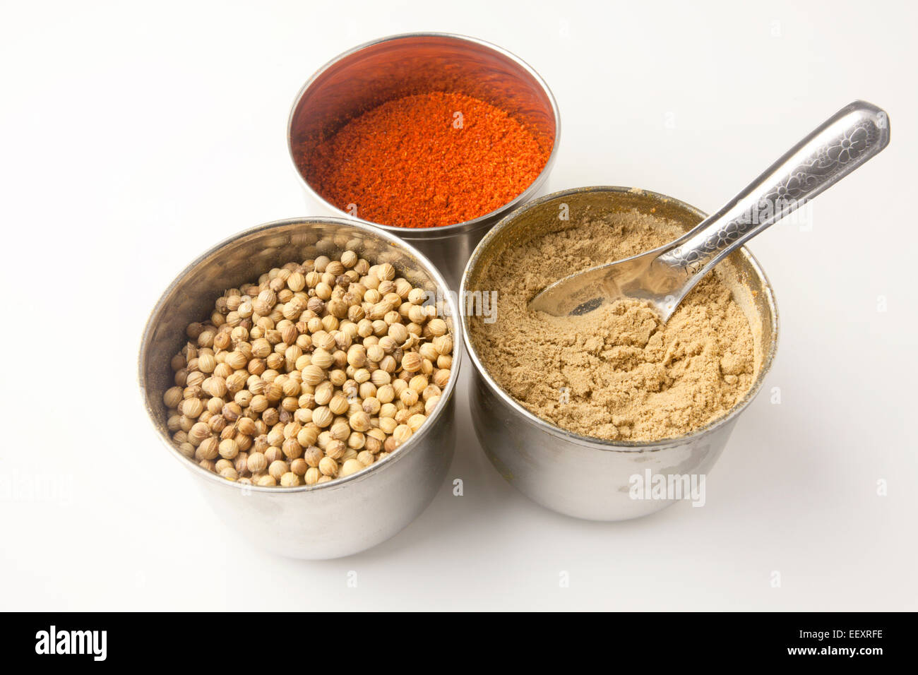 Edelstahl-Töpfe von gemahlenen Chili Corinader Samen und gemahlener Ingwer mit einem Messlöffel Stockfoto