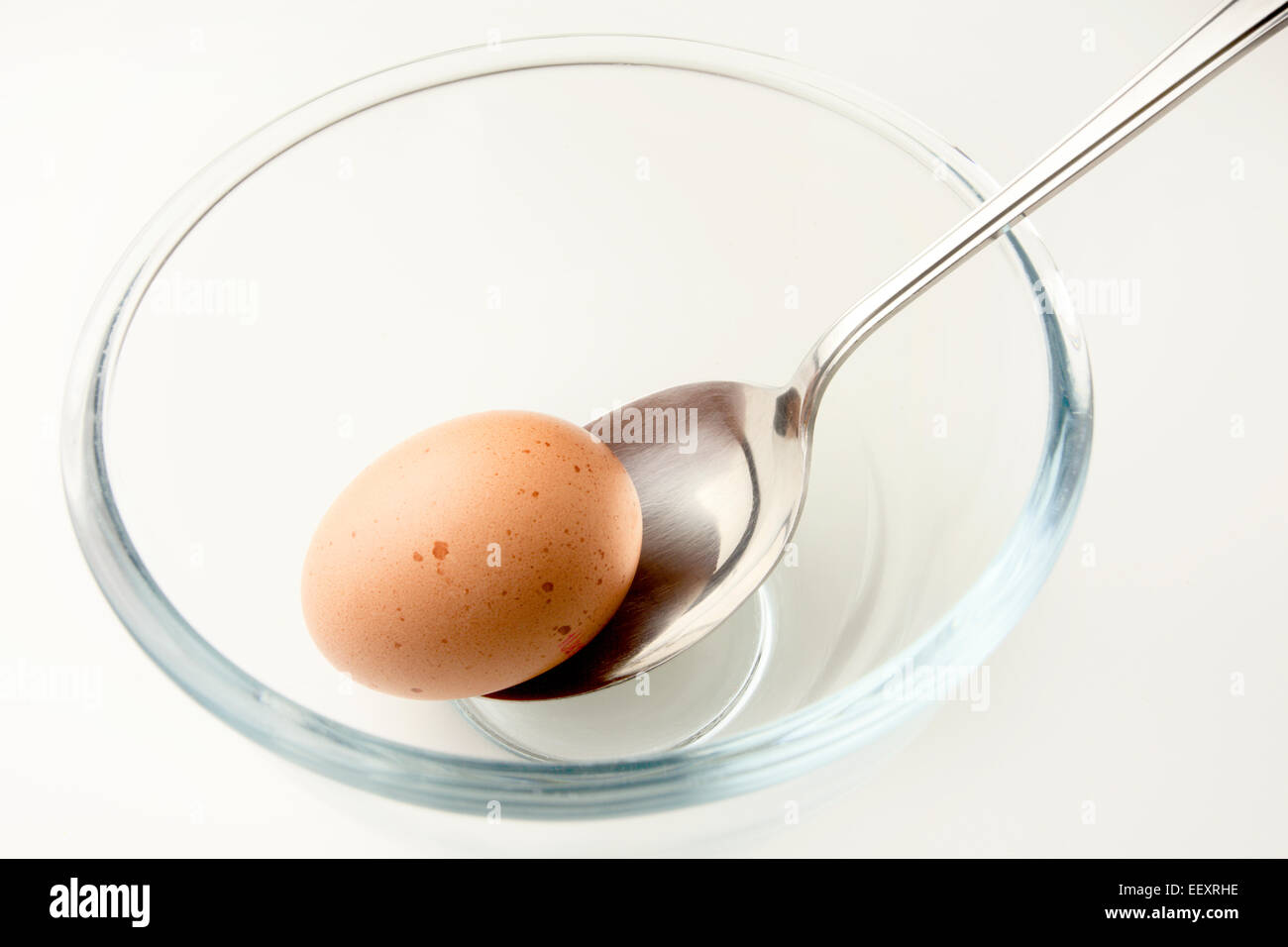 Braune Freilandhaltung Ei und Esslöffel in eine Glasschüssel Stockfoto