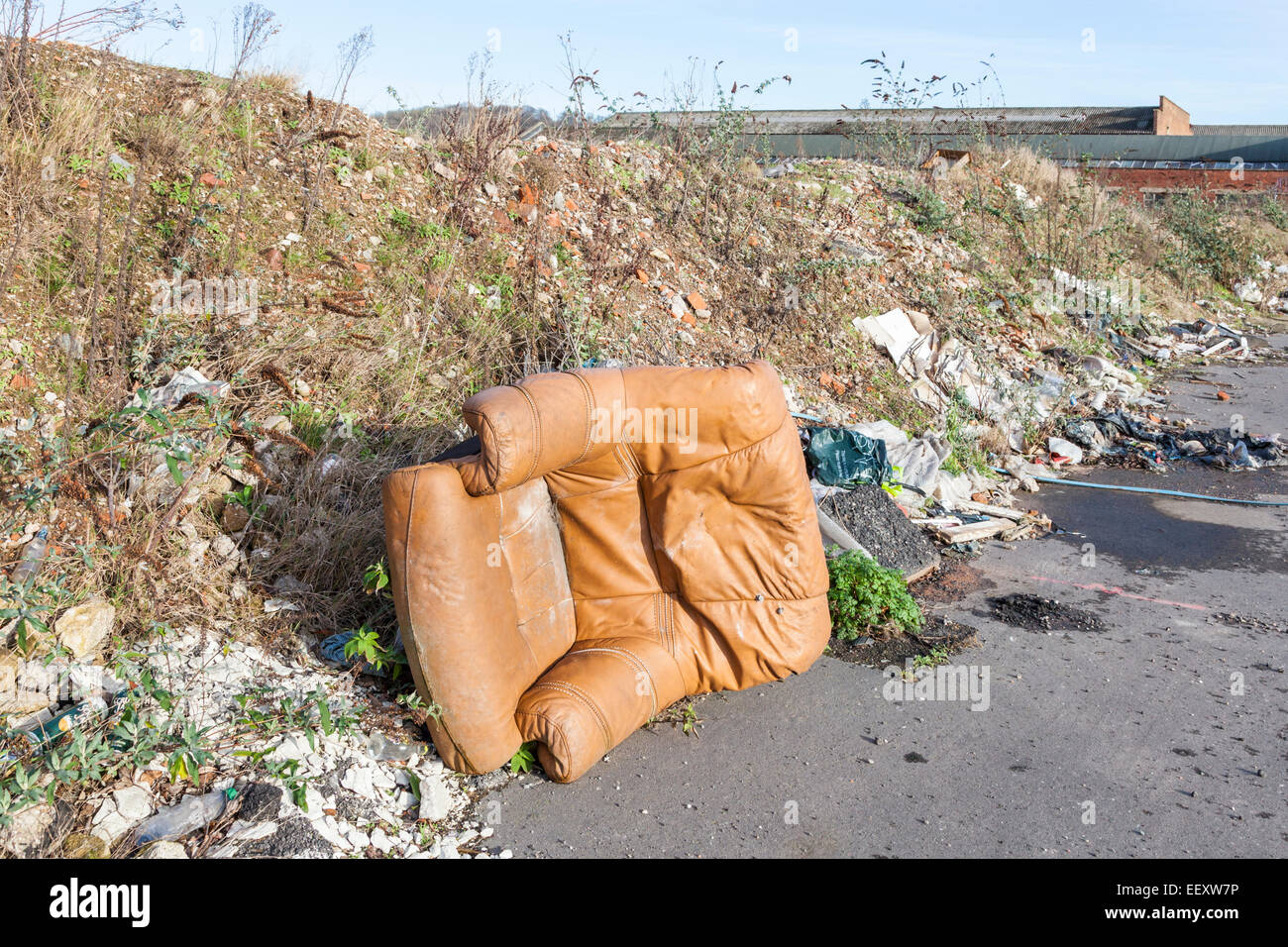 Kippen Fliegen. Die illegale Verklappung von einem Ledersessel, Abfall und anderen Müll auf einem Gehsteig am Rande einer Stadt. Nottingham, England, Großbritannien Stockfoto