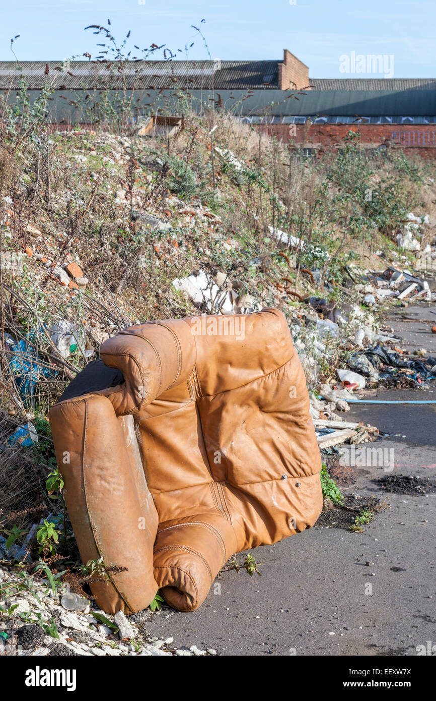 Kippen Fliegen. Die illegale Verklappung von einem Ledersessel, Abfall und anderen Müll auf einem Gehsteig am Rande einer Stadt. Nottingham, England, Großbritannien Stockfoto