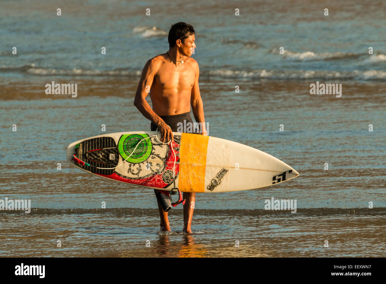 Surfer und Shortboard an diesem beliebten lebhafte Surfstrand in der Nähe von San Juan del Sur; Playa Maderas, San Juan del Sur, Rivas, Nicaragua Stockfoto