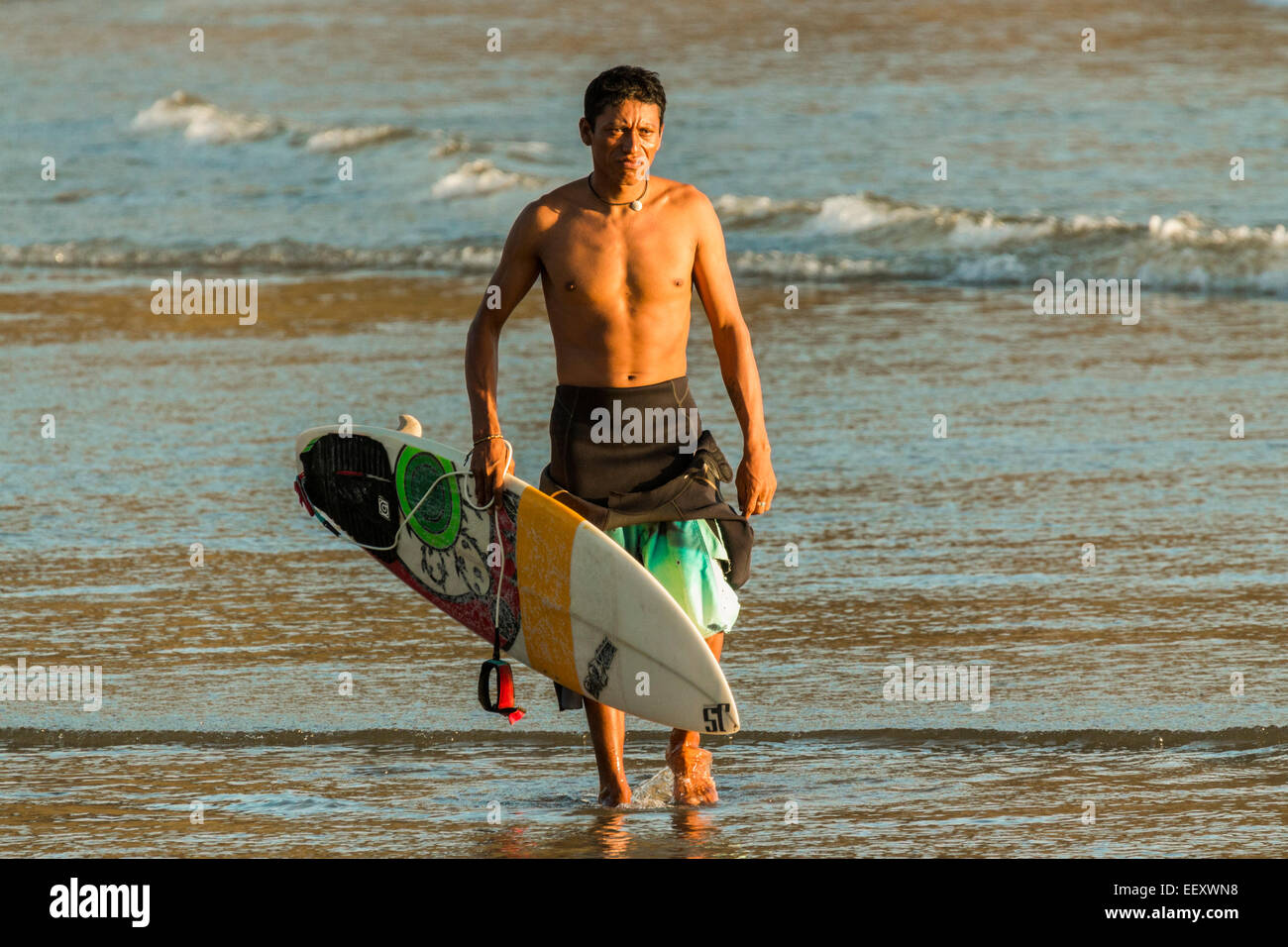 Surfer und Shortboard an diesem beliebten lebhafte Surfstrand in der Nähe von San Juan del Sur; Playa Maderas, San Juan del Sur, Rivas, Nicaragua Stockfoto