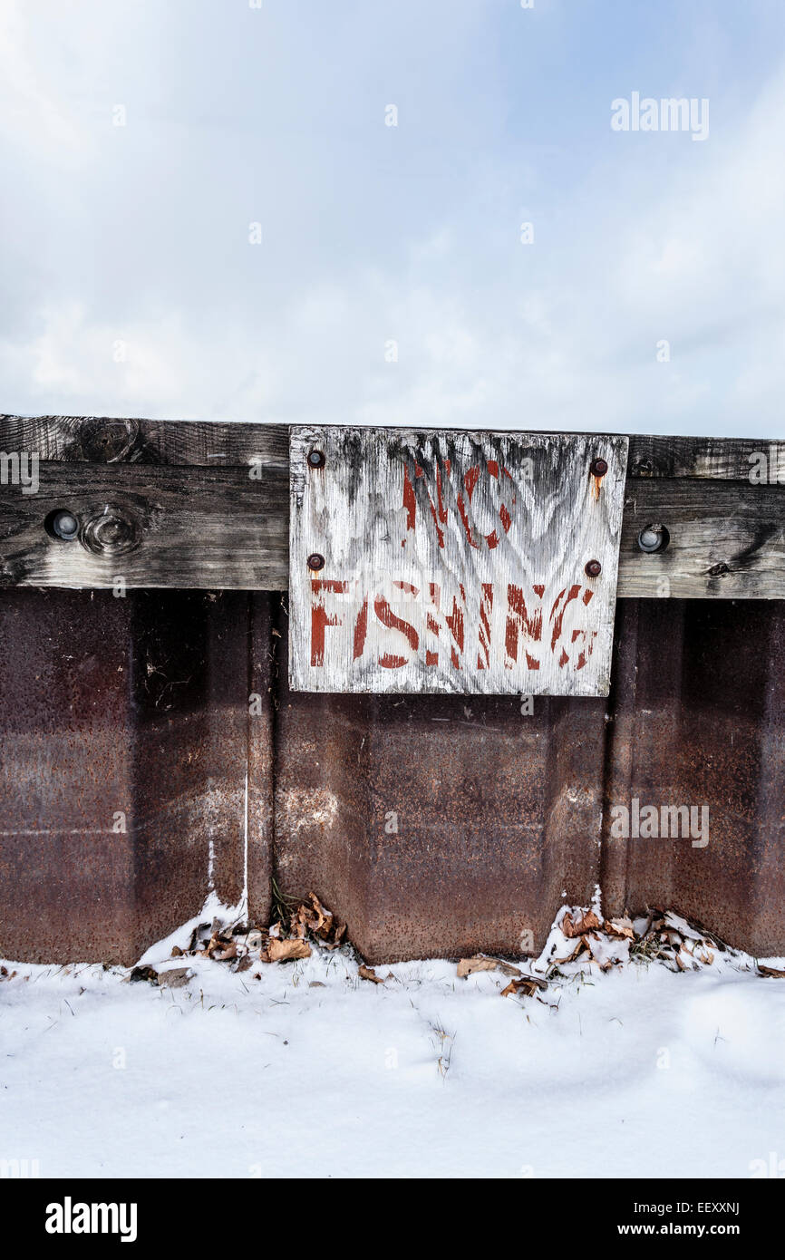 Eine gut getragen keine Fischerei-Zeichen auf einem rostigen alten Pier im Winter. Stockfoto