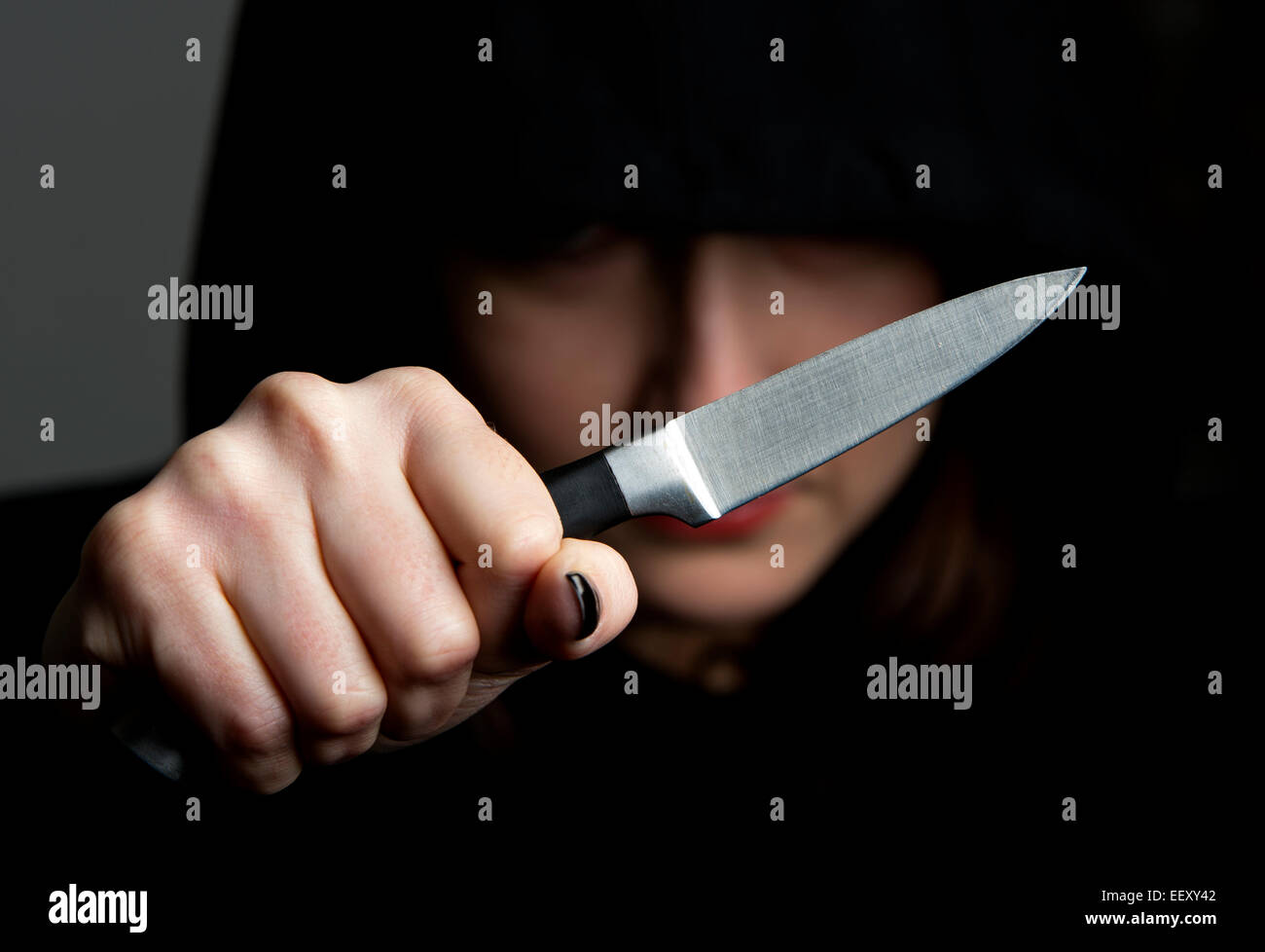 Frauen tragen ein Kapuzenshirt oder "Hoodie" schwang ein Messer als Symbol für Gang-Kultur. Stockfoto