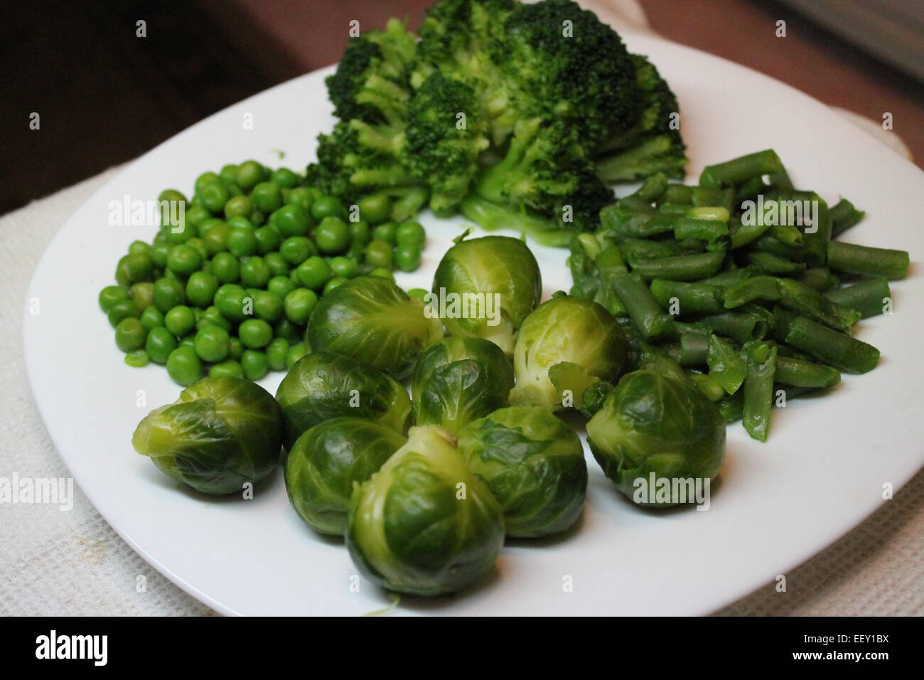 appetitlich frisches grünes Gemüse Brokkoli, Rosenkohl, Gartenbohnen, Erbsen lag auf der Platte Stockfoto