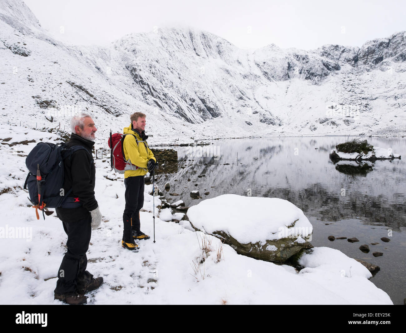 Zwei Wanderer Llyn Idwal See in Cwm Idwal mit Teufels Küche jenseits und Schnee in den Bergen in Snowdonia im Winter. CWM Idwal Ogwen Wales UK Stockfoto
