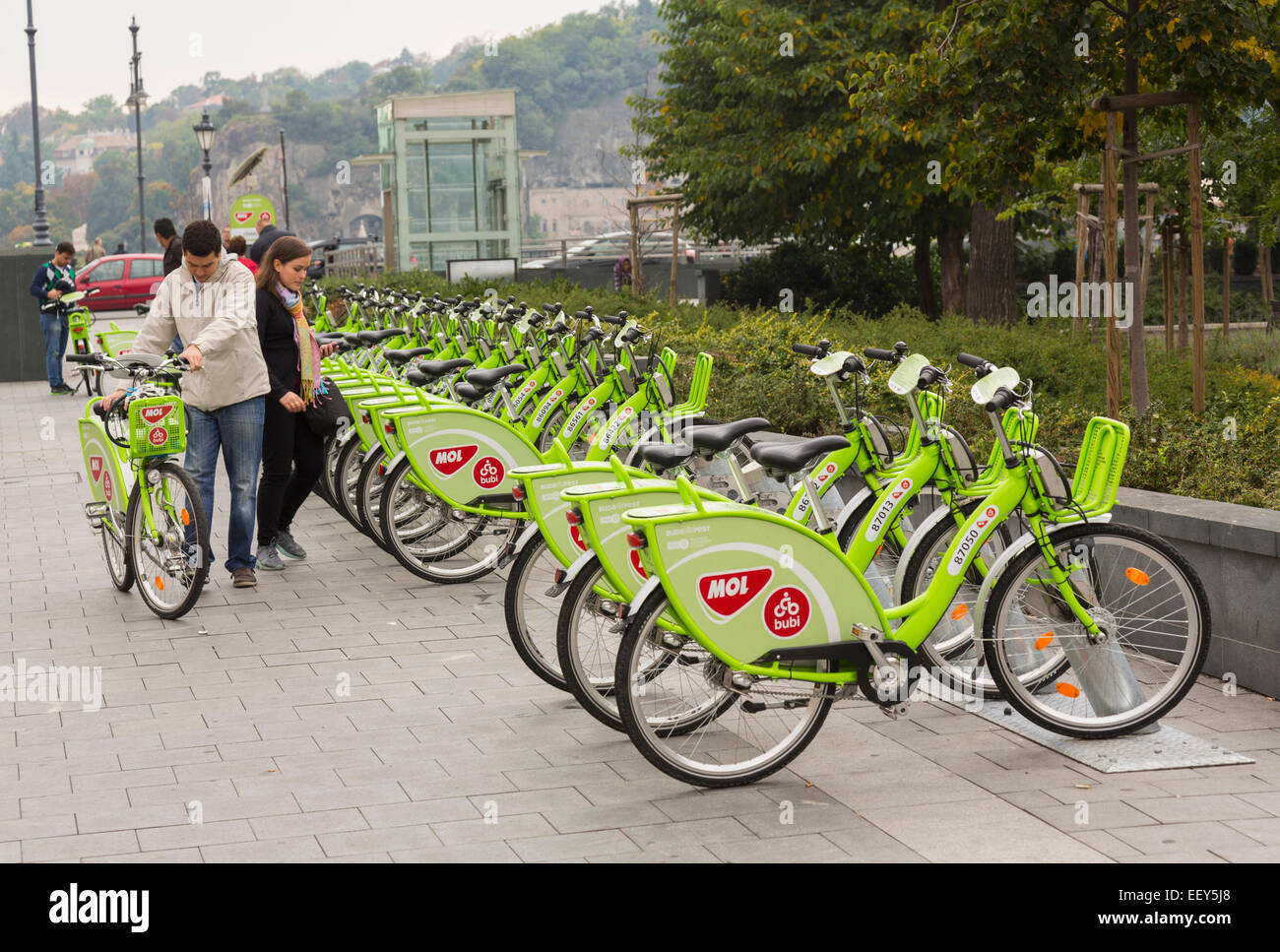 Paar über die Vermietung mieten Fahrräder genannt MOL Bubi oder NextBike auf Straßen von Budapest, Ungarn Stockfoto