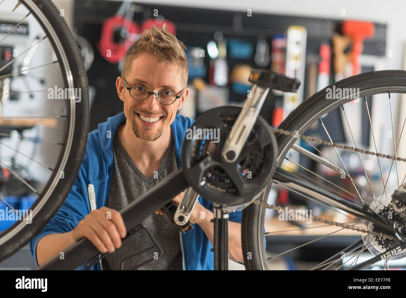 Mann Reparatur Fahrrad im shop Stockfoto